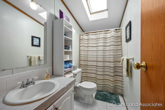 full bath with toilet, lofted ceiling with skylight, curtained shower, tile patterned flooring, and vanity