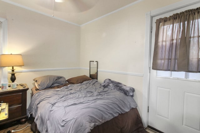 bedroom featuring ornamental molding, multiple windows, and ceiling fan