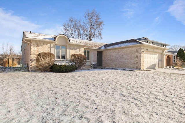 single story home featuring a garage, concrete driveway, and brick siding