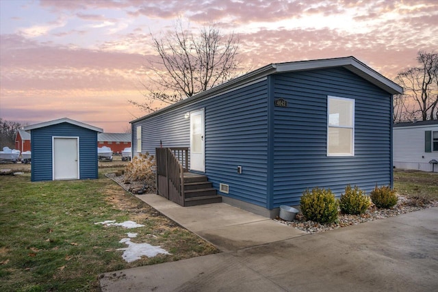 exterior space featuring a shed, a front lawn, and an outbuilding