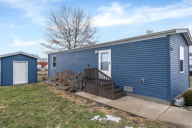 rear view of property featuring crawl space, a yard, a shed, and an outbuilding