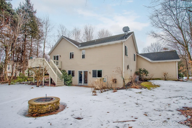 snow covered property featuring a fire pit, a wooden deck, and stairs