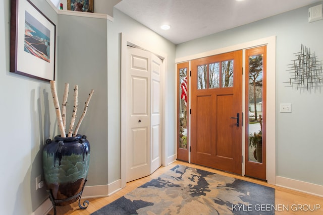 foyer with light wood finished floors and baseboards