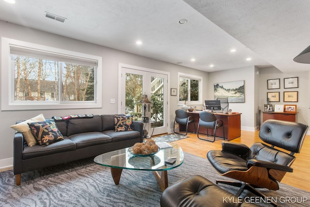 living room featuring baseboards, wood finished floors, visible vents, and recessed lighting