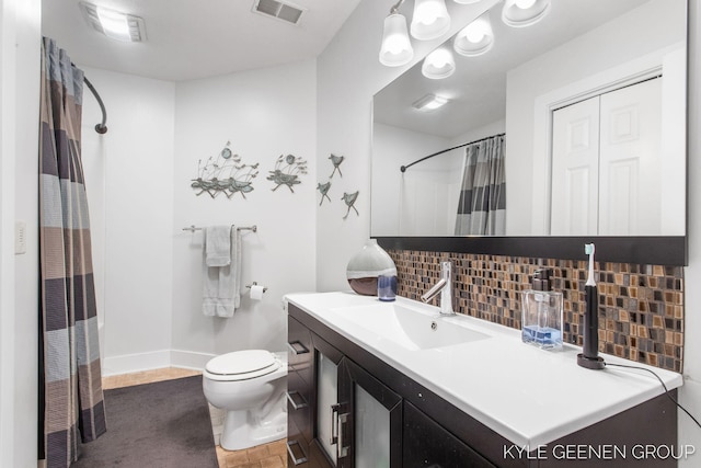 bathroom featuring visible vents, toilet, decorative backsplash, vanity, and baseboards