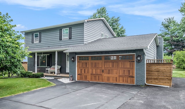 view of front of house with an attached garage, roof with shingles, a porch, and brick siding