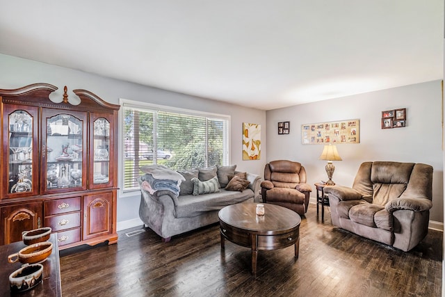 living area featuring dark wood-style flooring, visible vents, and baseboards