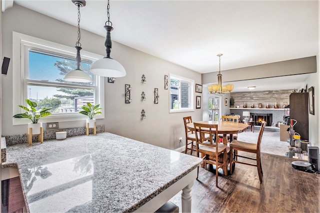 dining area with a brick fireplace and wood finished floors