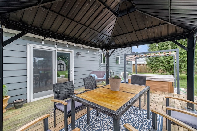 wooden deck with a gazebo, fence, and a hot tub