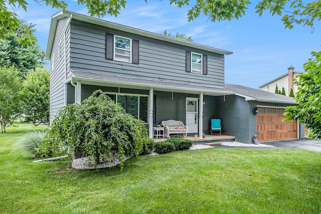 traditional-style house featuring brick siding, a porch, an attached garage, and a front yard