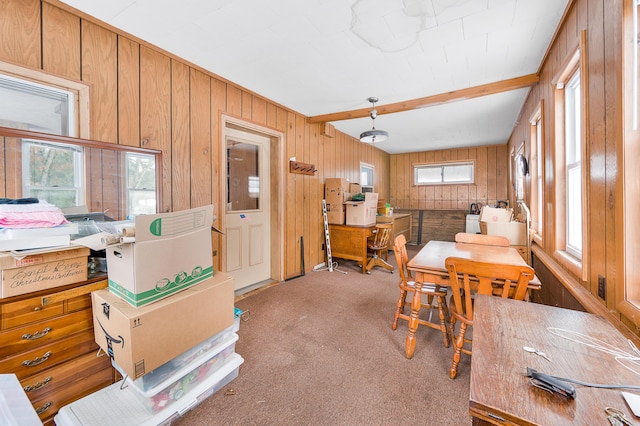 dining area featuring wood walls and light colored carpet