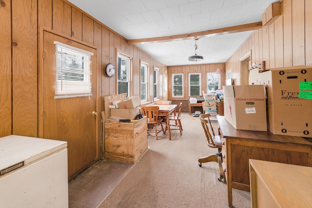 carpeted office with wood walls and beam ceiling