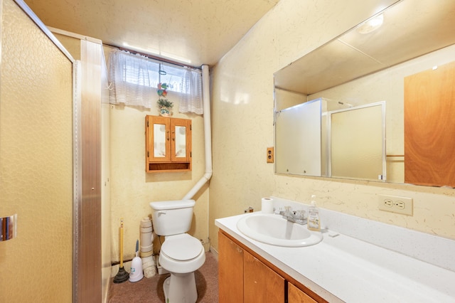 full bathroom with toilet, a textured wall, a shower stall, and vanity