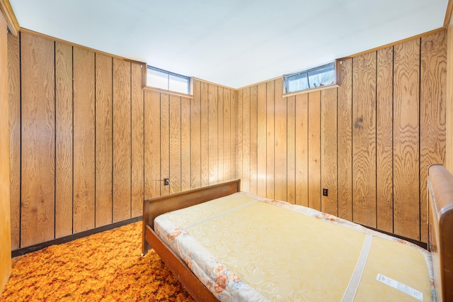 bedroom with multiple windows and wood walls