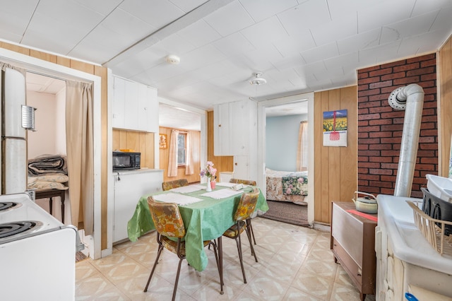 dining area with light floors and wood walls