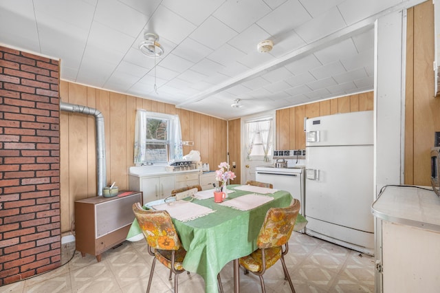 dining room with light floors and wood walls