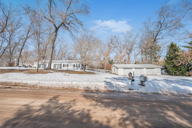 view of front of house featuring a detached garage, driveway, and an outdoor structure