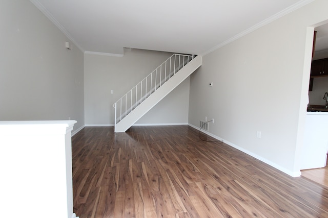 unfurnished living room featuring crown molding, a sink, wood finished floors, baseboards, and stairs