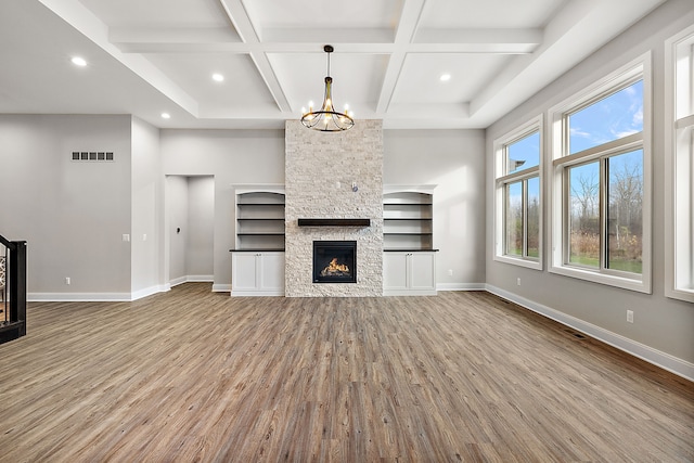 unfurnished living room featuring a fireplace, baseboards, and wood finished floors