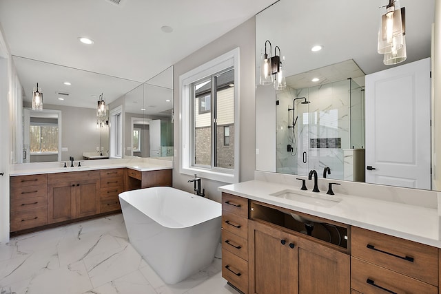 bathroom featuring marble finish floor, a freestanding bath, a marble finish shower, and a sink