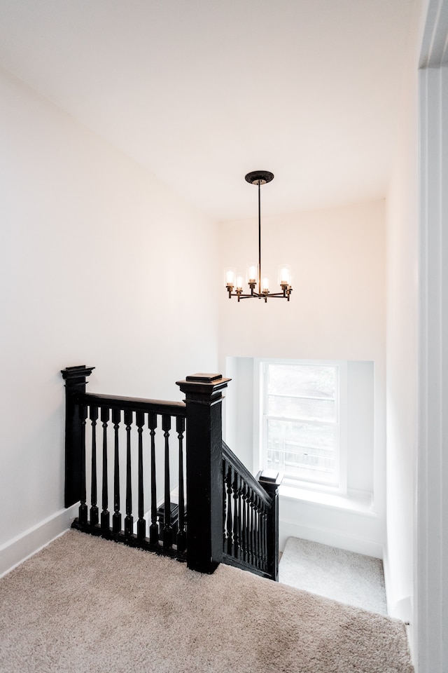 stairs featuring baseboards, carpet floors, and a notable chandelier