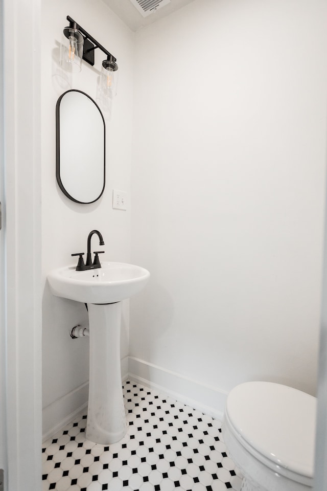 bathroom featuring visible vents, toilet, and baseboards