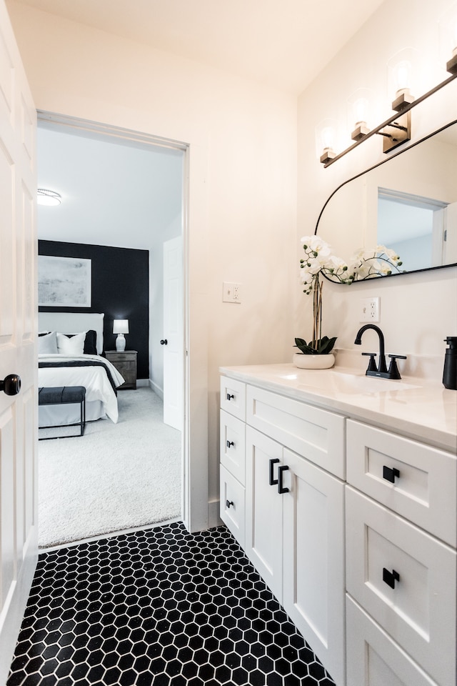 ensuite bathroom featuring ensuite bath, baseboards, and vanity