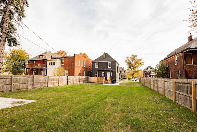 view of yard featuring a residential view, a fenced backyard, and entry steps