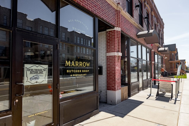 entrance to property featuring brick siding