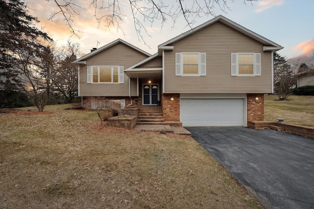 view of front of house featuring an attached garage, brick siding, and driveway