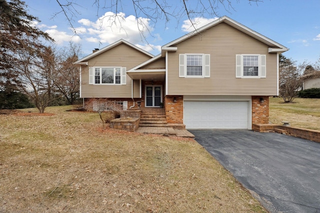 split foyer home with aphalt driveway, brick siding, and an attached garage