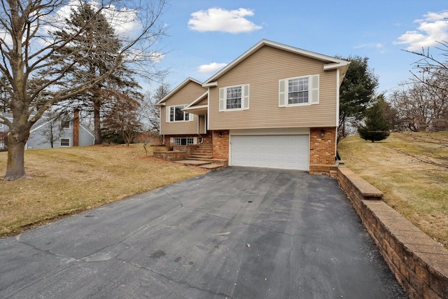 view of front facade featuring a front lawn, an attached garage, brick siding, and driveway