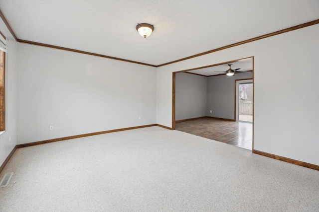 carpeted empty room with visible vents, baseboards, and ornamental molding