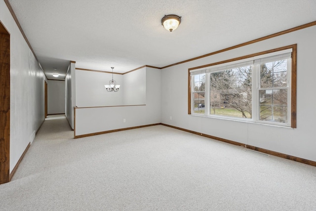 spare room featuring a chandelier, light colored carpet, a textured ceiling, and crown molding