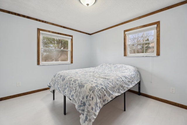 bedroom featuring multiple windows, a textured ceiling, and baseboards