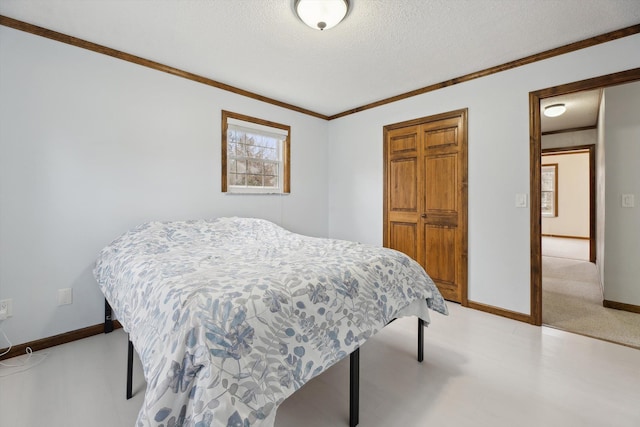 bedroom with a closet, baseboards, a textured ceiling, and ornamental molding