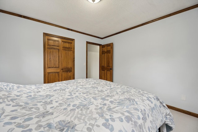 bedroom featuring a textured ceiling, baseboards, and ornamental molding