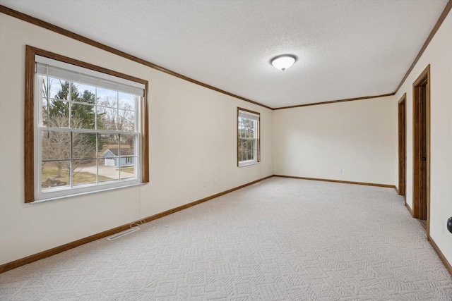 unfurnished room featuring crown molding, light colored carpet, and visible vents