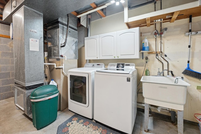 washroom with cabinet space, independent washer and dryer, and a sink