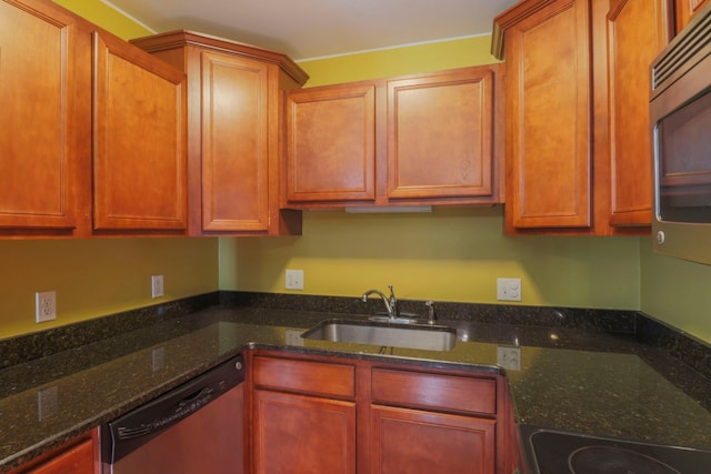 kitchen featuring a sink, stainless steel appliances, and dark stone countertops