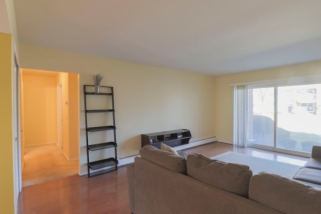 living room featuring a baseboard heating unit, dark wood finished floors, and baseboards