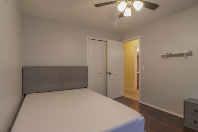 bedroom featuring a closet, baseboards, a ceiling fan, and dark wood-style flooring