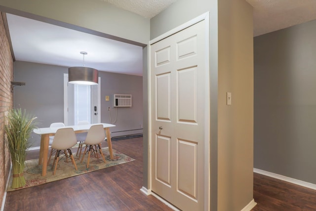 dining room featuring an AC wall unit, dark wood-type flooring, baseboards, and a baseboard radiator