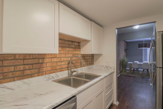 kitchen with white cabinets, stainless steel appliances, light countertops, and a sink