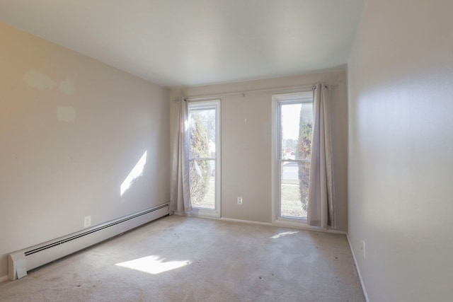 empty room with a baseboard heating unit, carpet, and baseboards