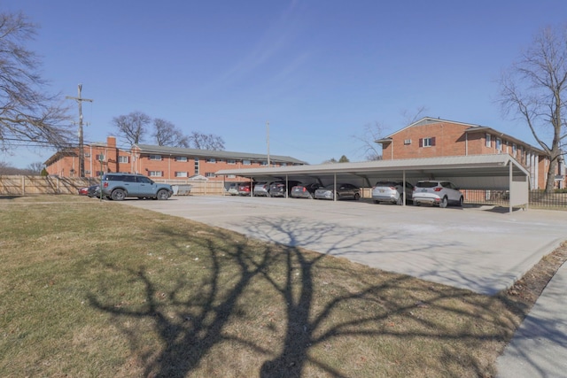 partially covered parking lot featuring fence