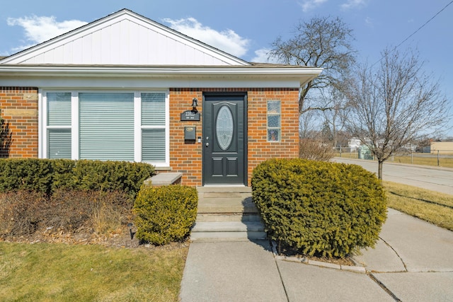 doorway to property featuring brick siding