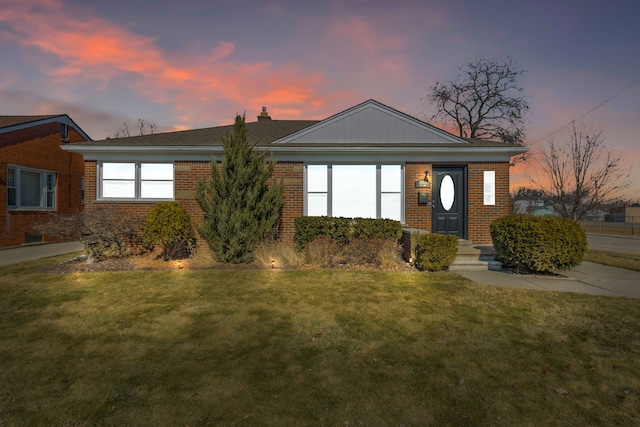 single story home featuring a front lawn and brick siding