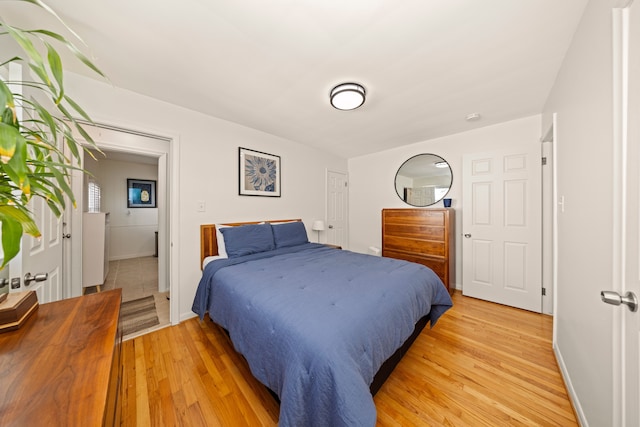 bedroom with light wood finished floors and baseboards