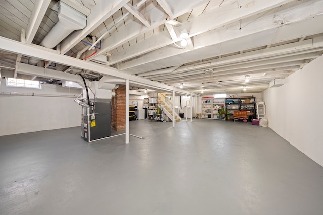 below grade area featuring heating unit, stairs, and washer and clothes dryer